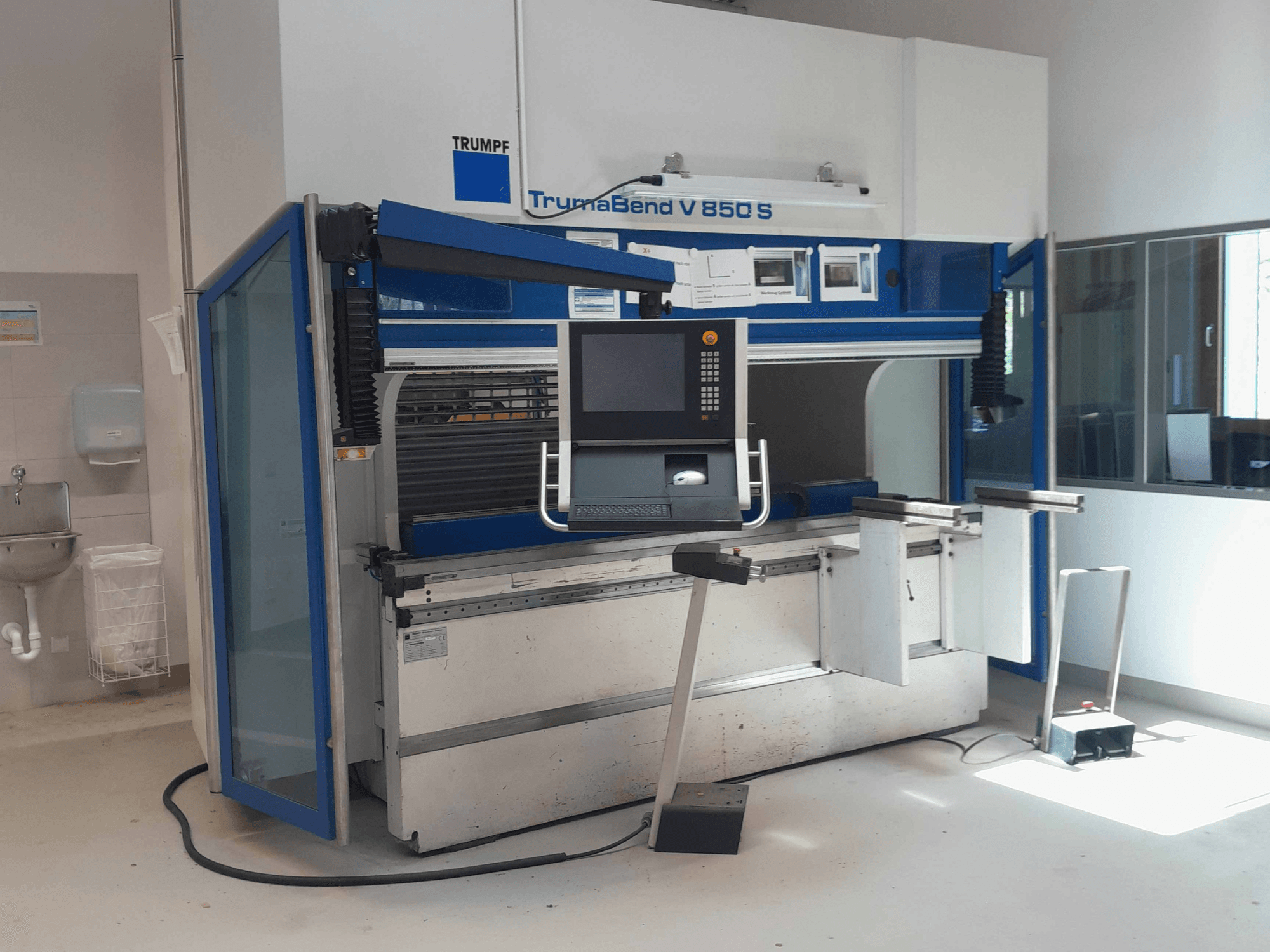 TRUMPF TrumaBend V 850 S painutuspress, vaade eest koos juhtpaneeli ja ohutusseadmetega valgusküllases töökeskkonnas.