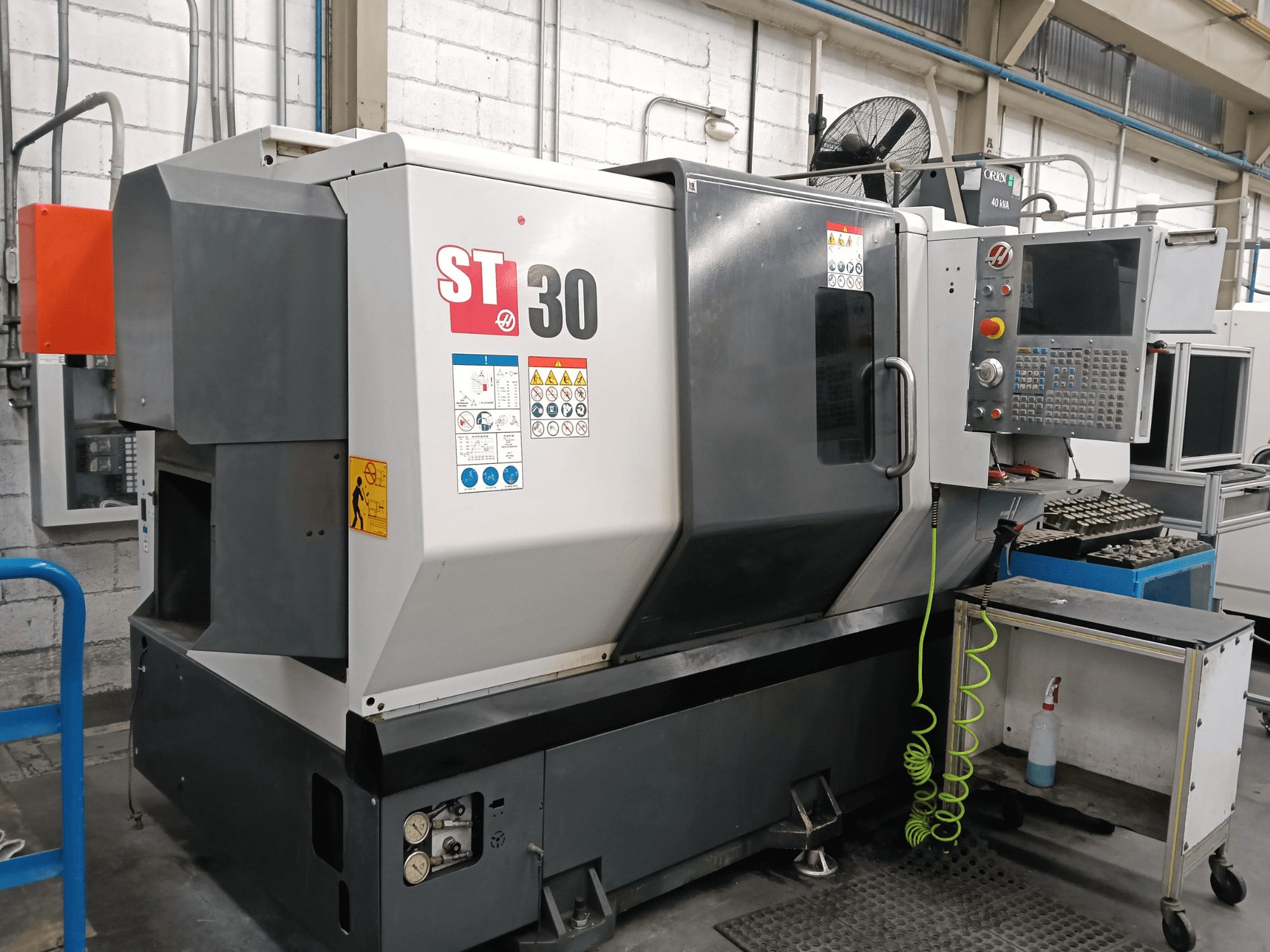 Alternatiivtekst: HAAS ST-30 horisontaalse treipingi vaade eest, millel on juhtpaneel, ohutusmärgised ja tööriistad lähedal asuval käru peal.