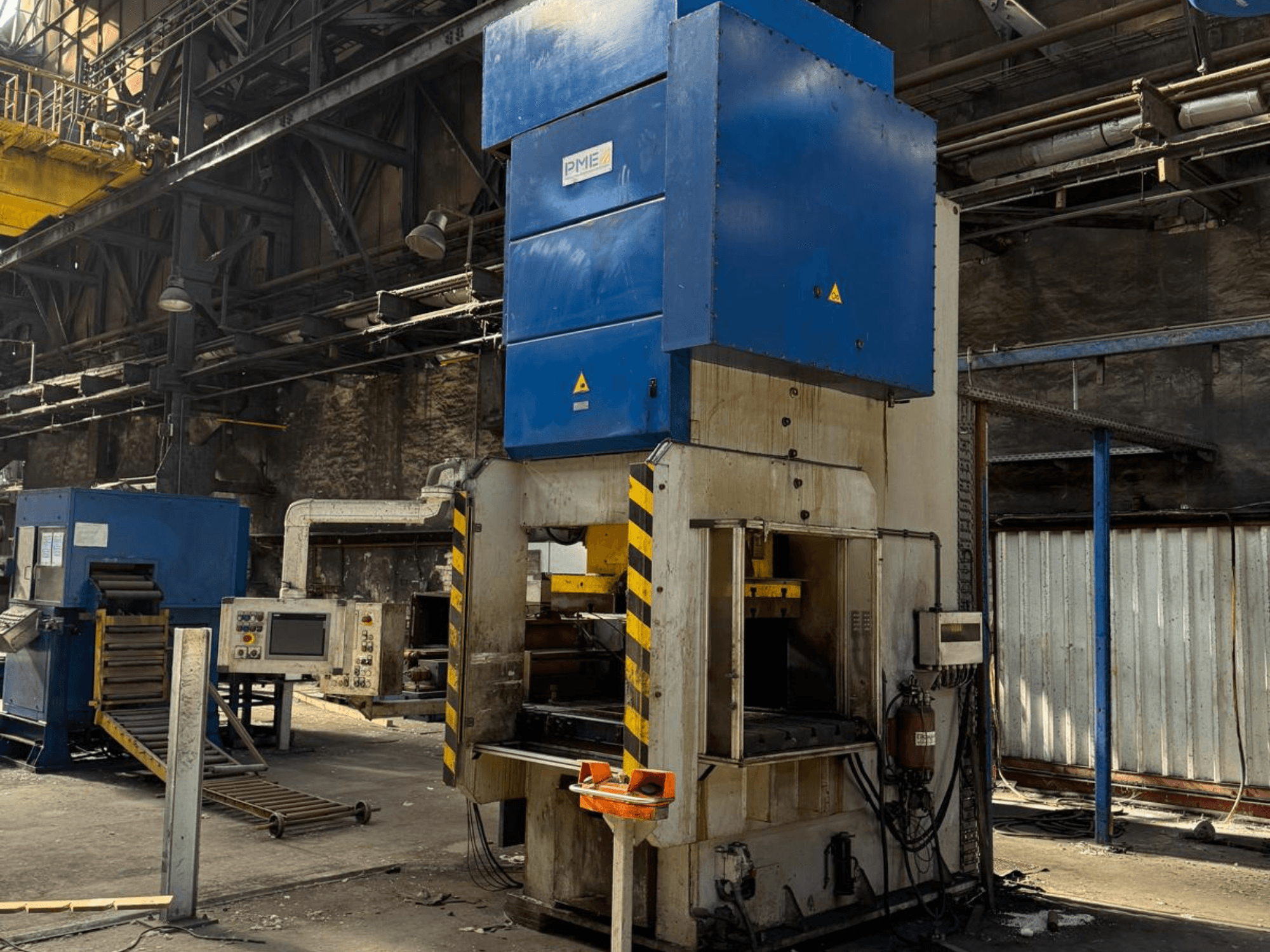 PME PE 400-1700 C mehaaniline stantsimispress, vaade eest, millel on näha sinine ülaosa ja kollaste triipudega alus tehase keskkonnas.