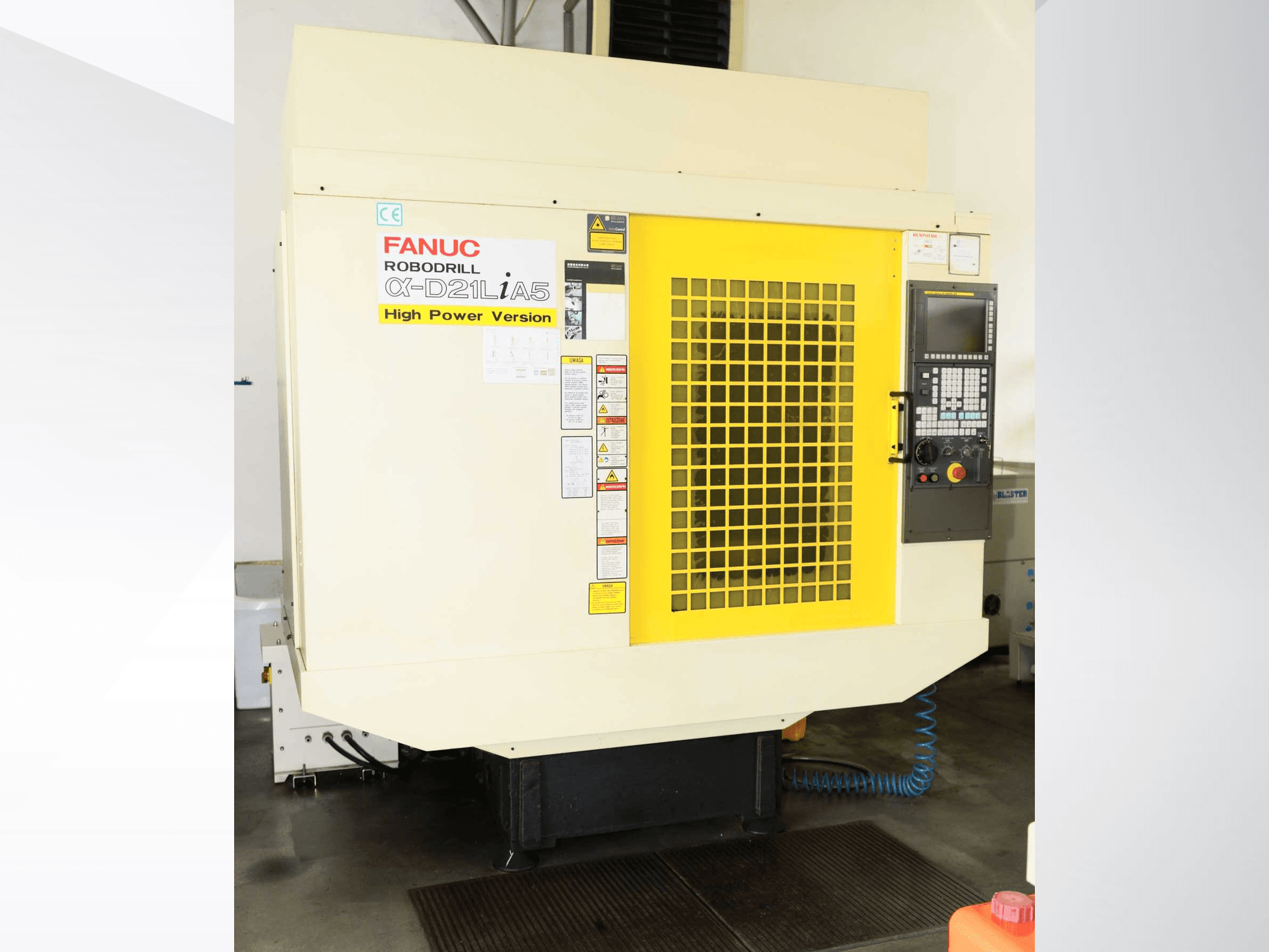 FANUC ROBODRILL α-D21LiA5 vertikaalne töötlemiskeskus, esivaade koos kollase turvavõre ja juhtpaneeli detailidega.
