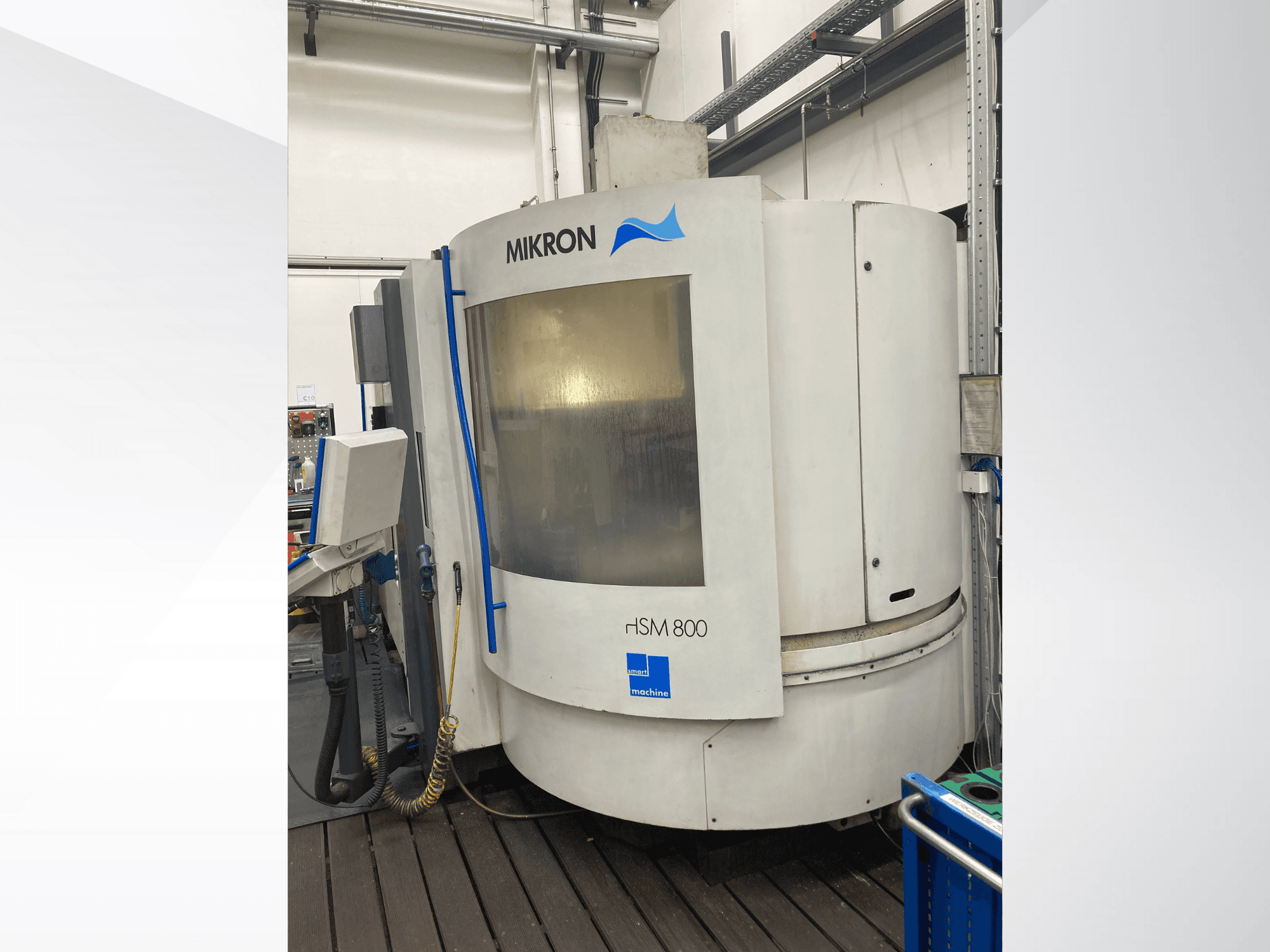 Mikron rISM 800 CNC-tööpink, esikülg juhtpaneeliga, silindriline disain ja sinised aktsendid, seatud töökojakeskkonda.