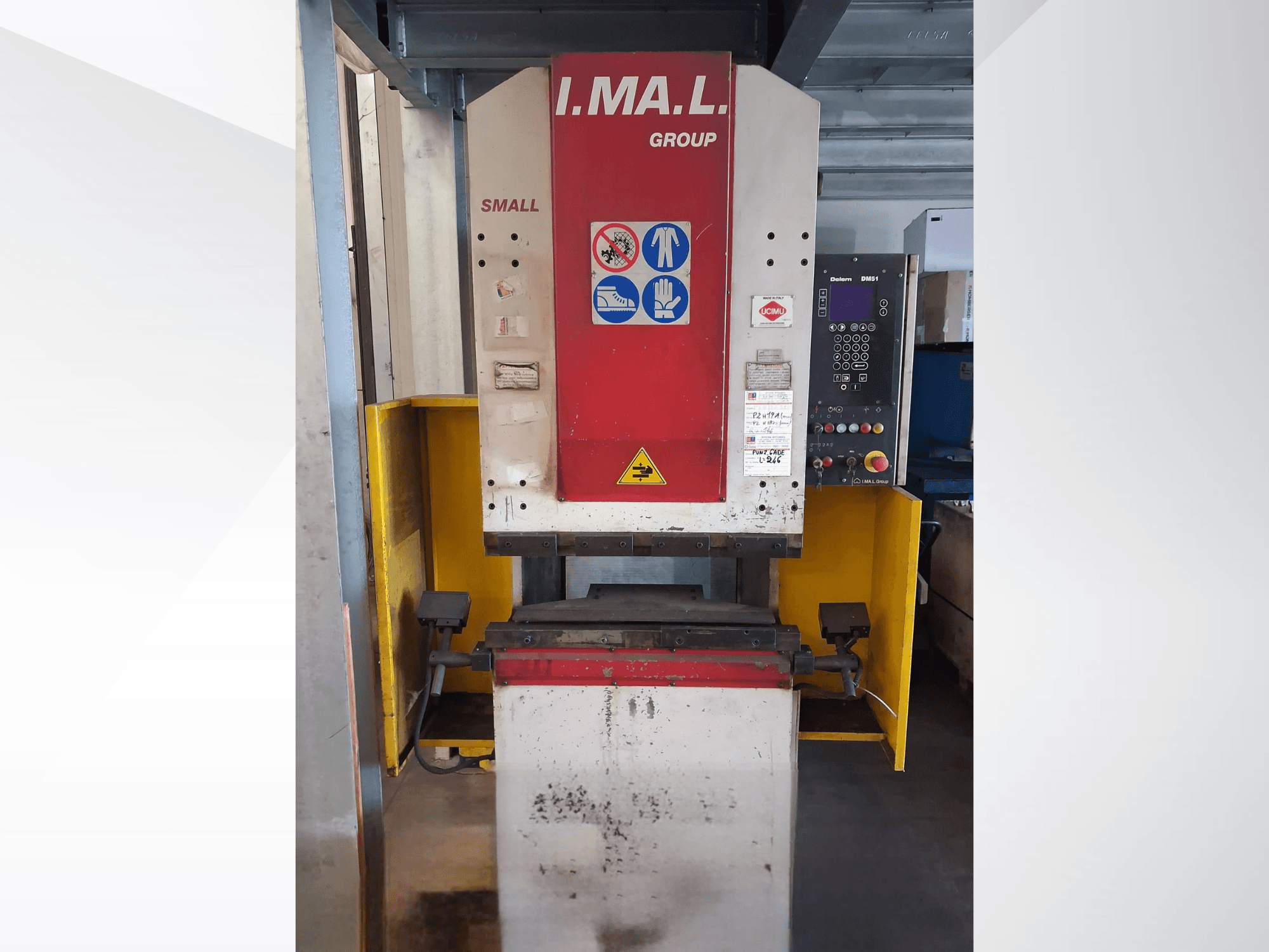 IMAL SMALL 835/25 painutuspressi esivaade koos juhtpaneeli, ohutusmärkide ja kollase kaitsepiirdega.