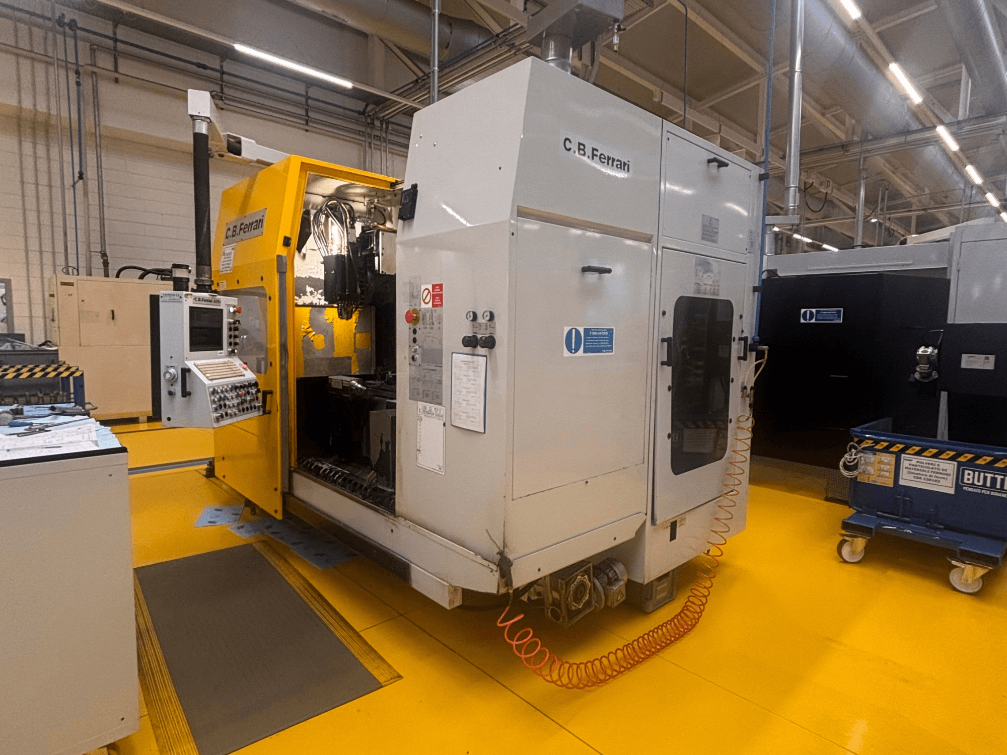 C.B. Ferrari A175 vertikaalne töötluskeskus tehase seadistuses, esiplaanil, juhtpaneel ja avatud juurdepääsu uks nähtavad.