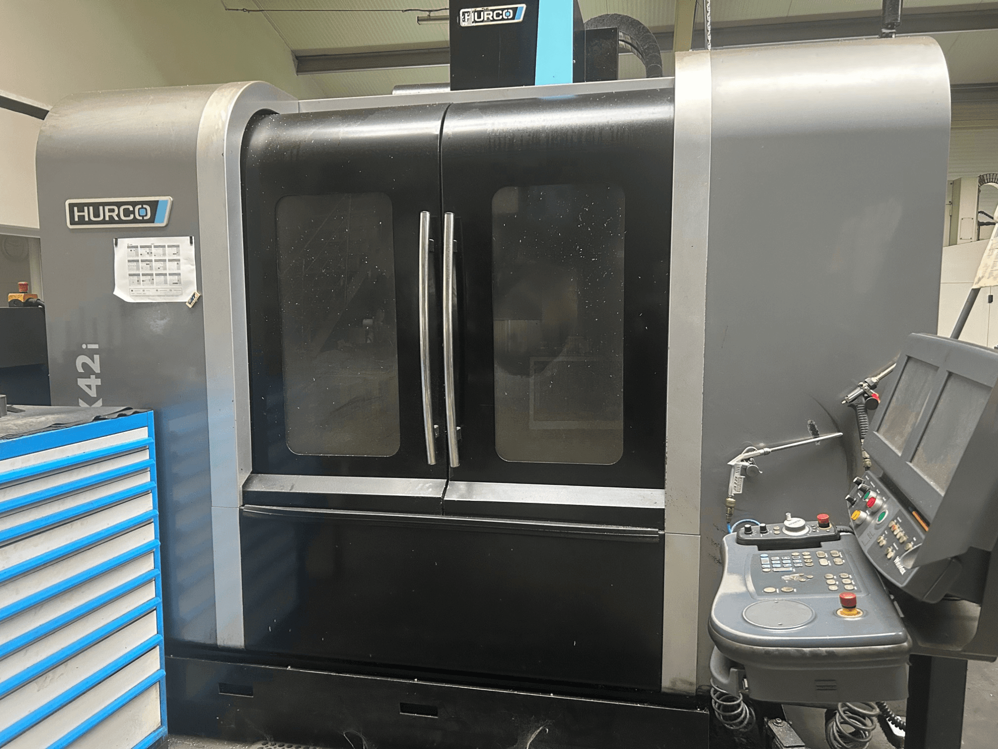 Hurco VMX42i CNC-tööpink, esivaade koos küljel asuva juhtpaneeliga, millel on topeltuksed ja nähtavad tehnilised üksikasjad.