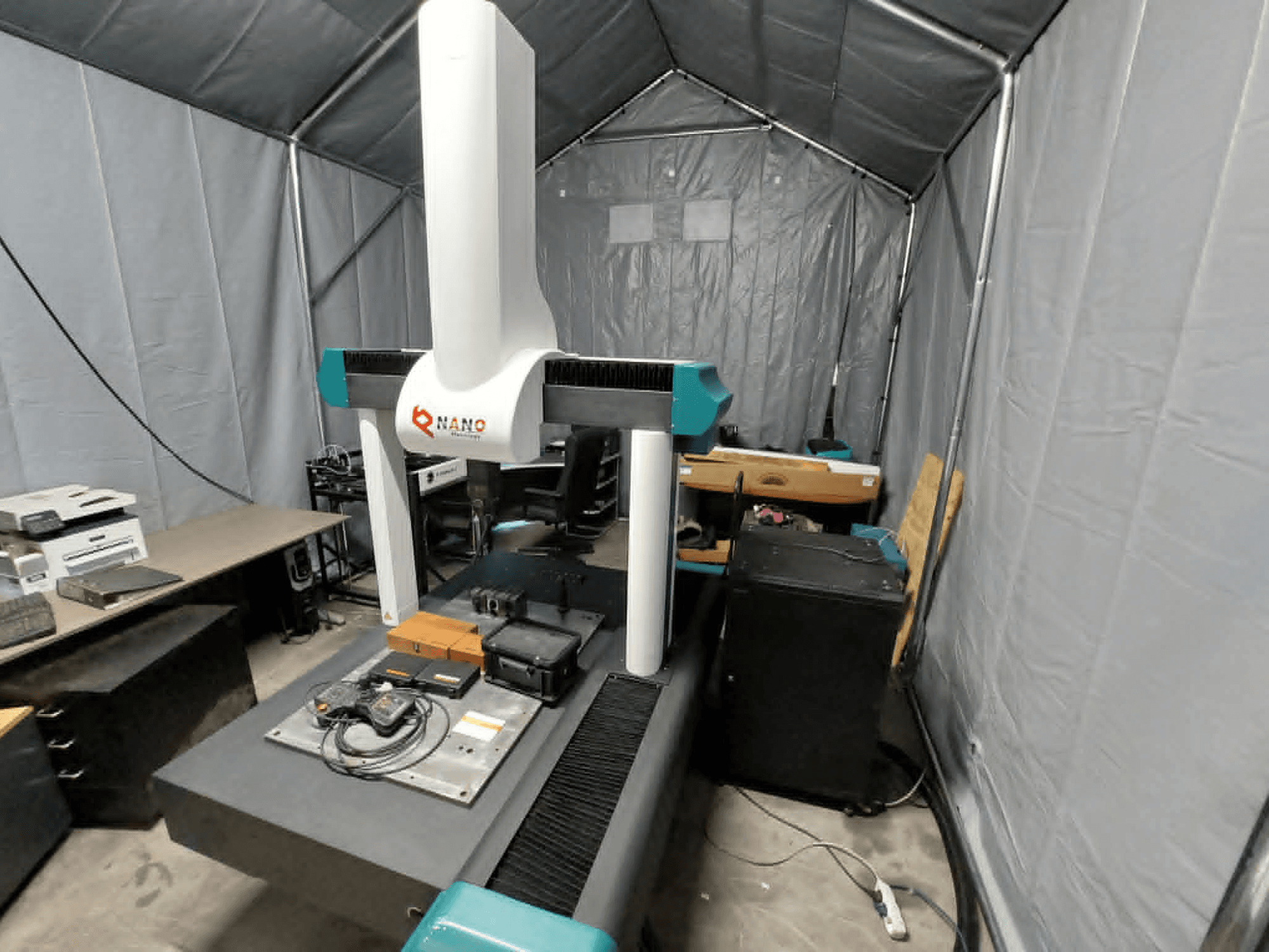 NANO METROLOGY Micr 7106 CMM telgis; esiplaanil on masina käsi ja mõõteplatvorm koos tarvikutega.