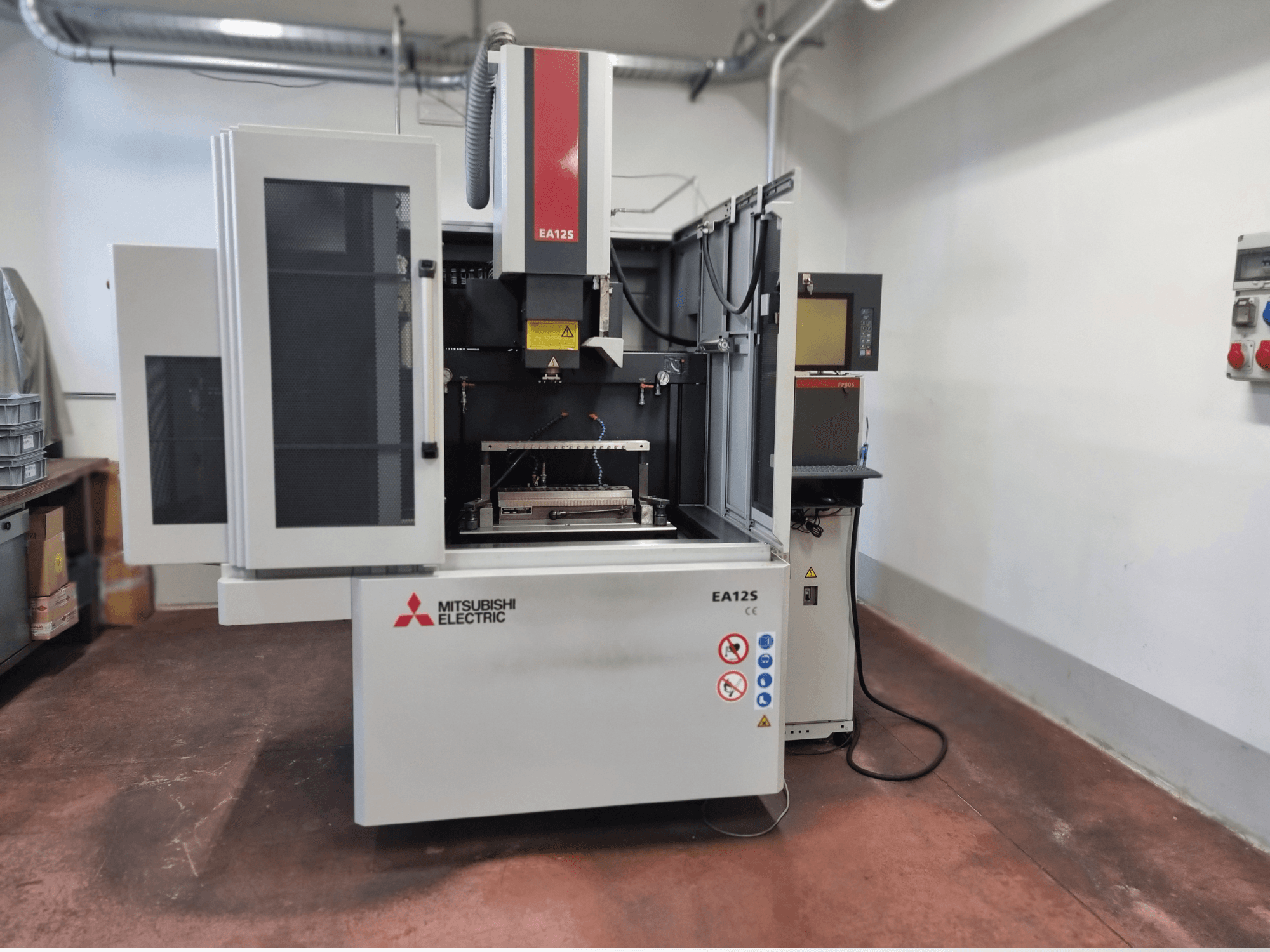Mitsubishi Electric EA12S traadilõikepink, esivaade, avatud uksed, juhtpaneel ja ohutussildid.